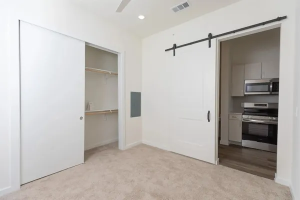 a view of a kitchen with a closet and electronic appliances