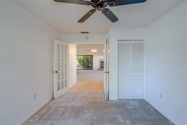 a view of a room with a ceiling fan and entryway