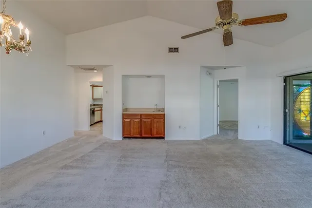 an empty room with windows and ceiling fan view