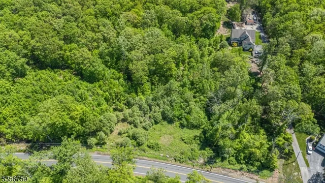 an aerial view of residential house with outdoor space and trees all around
