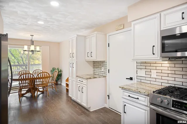 a kitchen with stainless steel appliances stove top oven table and chairs