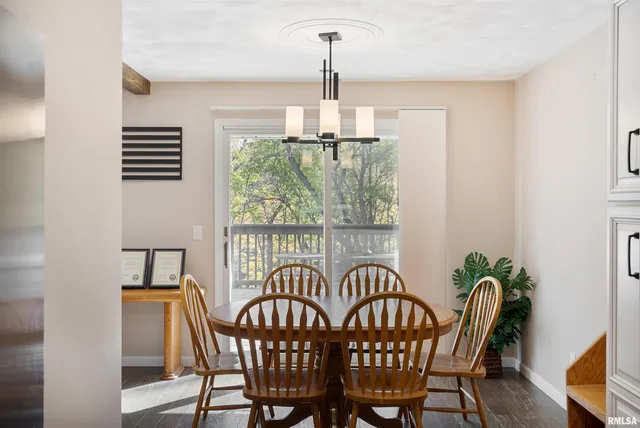 a dining room with furniture a chandelier and window