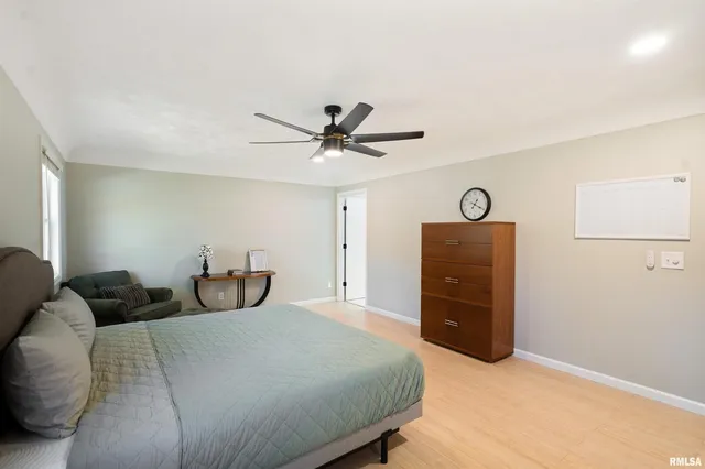 a bedroom with a bed and a ceiling fan