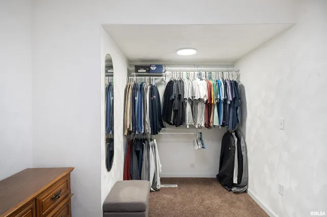 a view of walk in closet with clothes