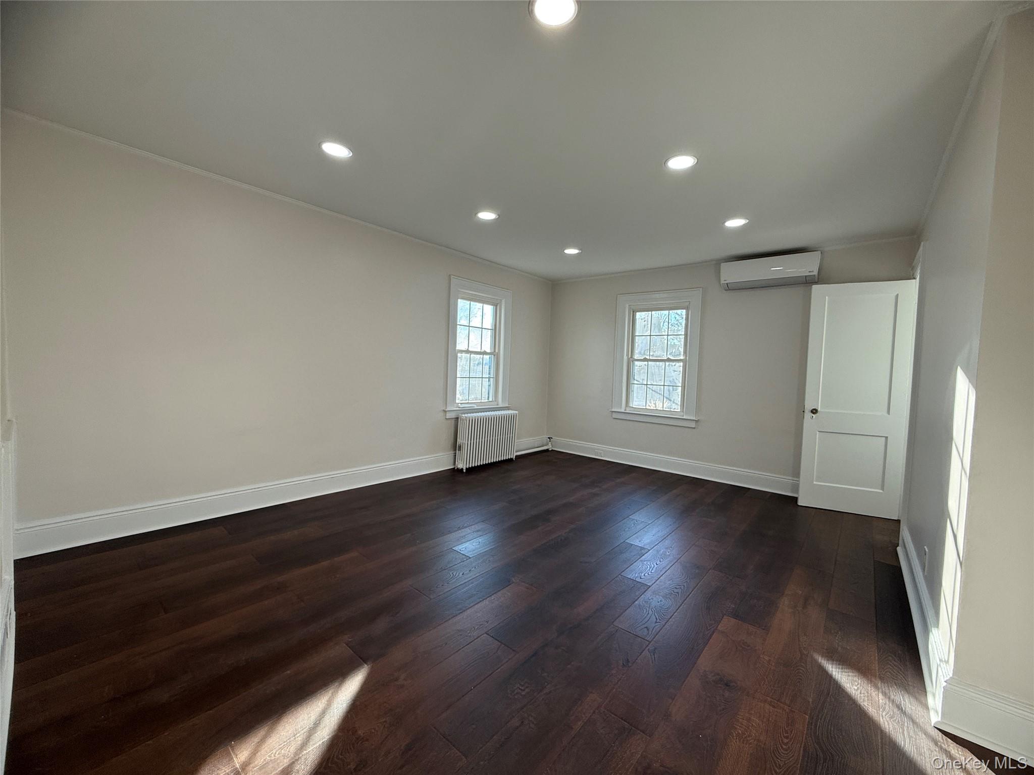 71 Hillcrest Avenue Manhasset, NY 11030 - Photo 14 of 23 an empty room with wooden floor and windows
