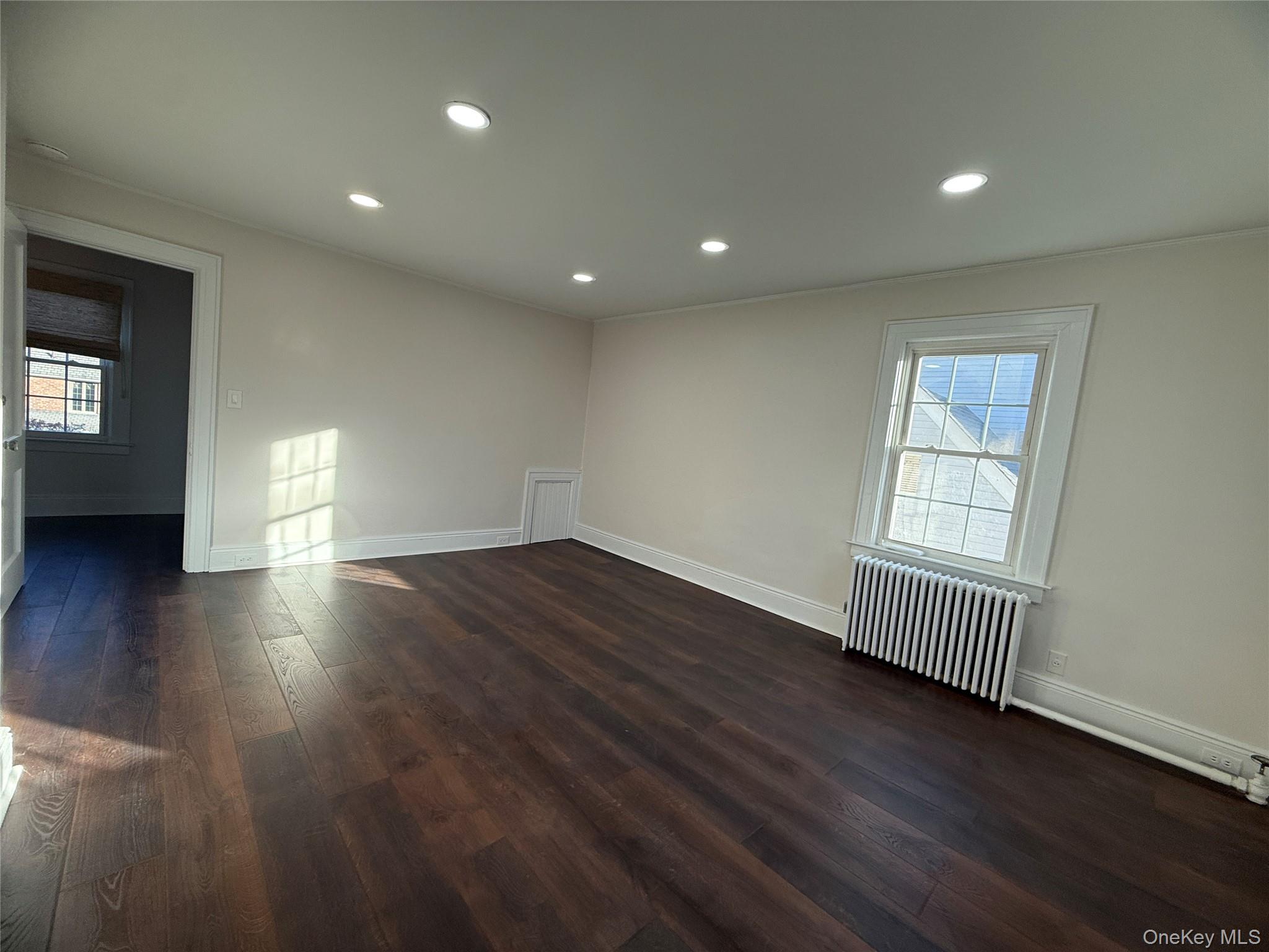 71 Hillcrest Avenue Manhasset, NY 11030 - Photo 16 of 23 an empty room with wooden floor and windows
