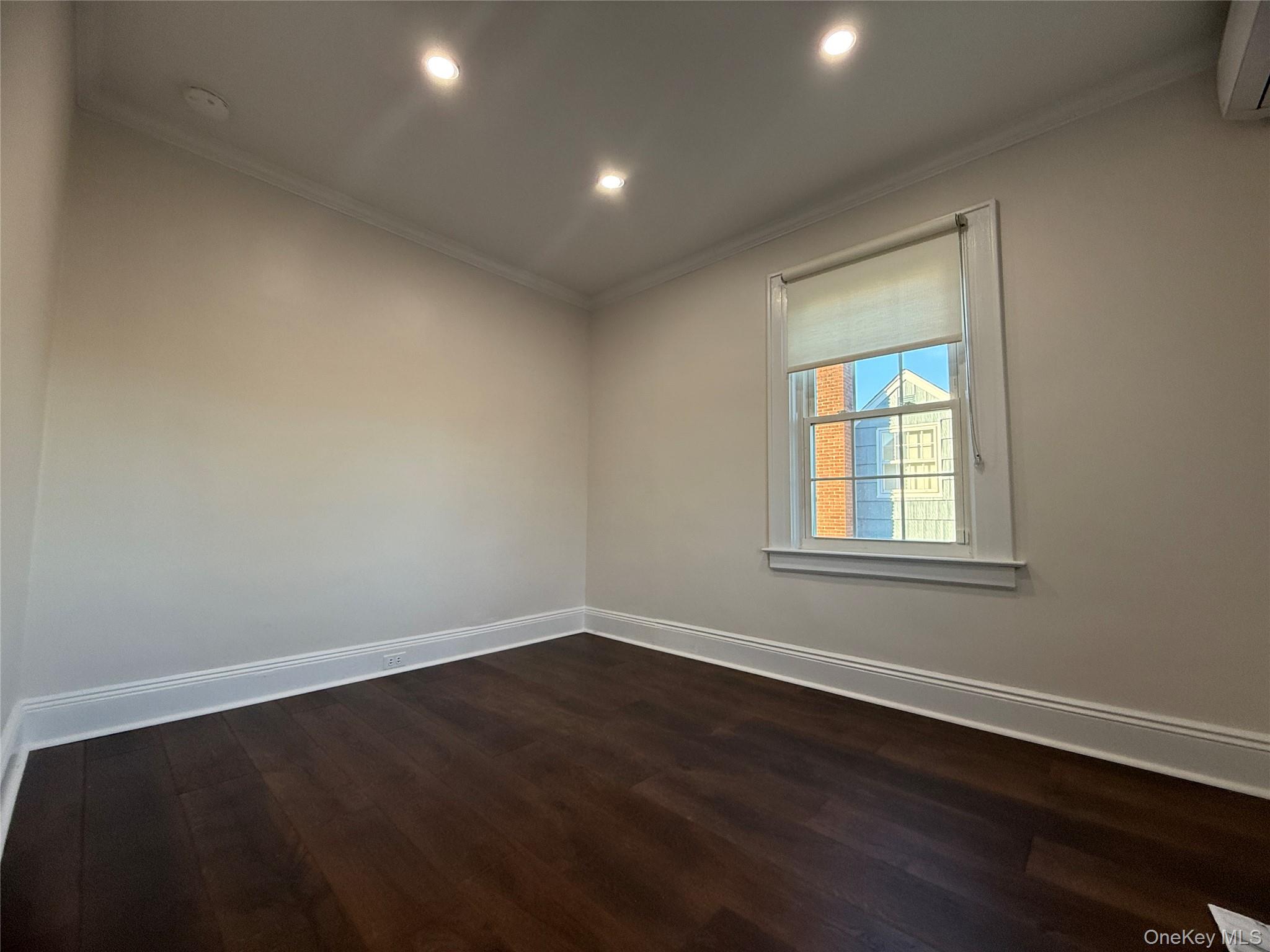 71 Hillcrest Avenue Manhasset, NY 11030 - Photo 17 of 23 an empty room with wooden floor and windows