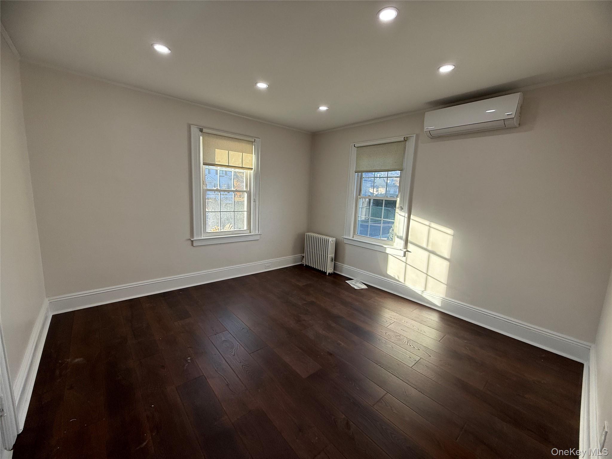 71 Hillcrest Avenue Manhasset, NY 11030 - Photo 18 of 23 an empty room with wooden floor and windows