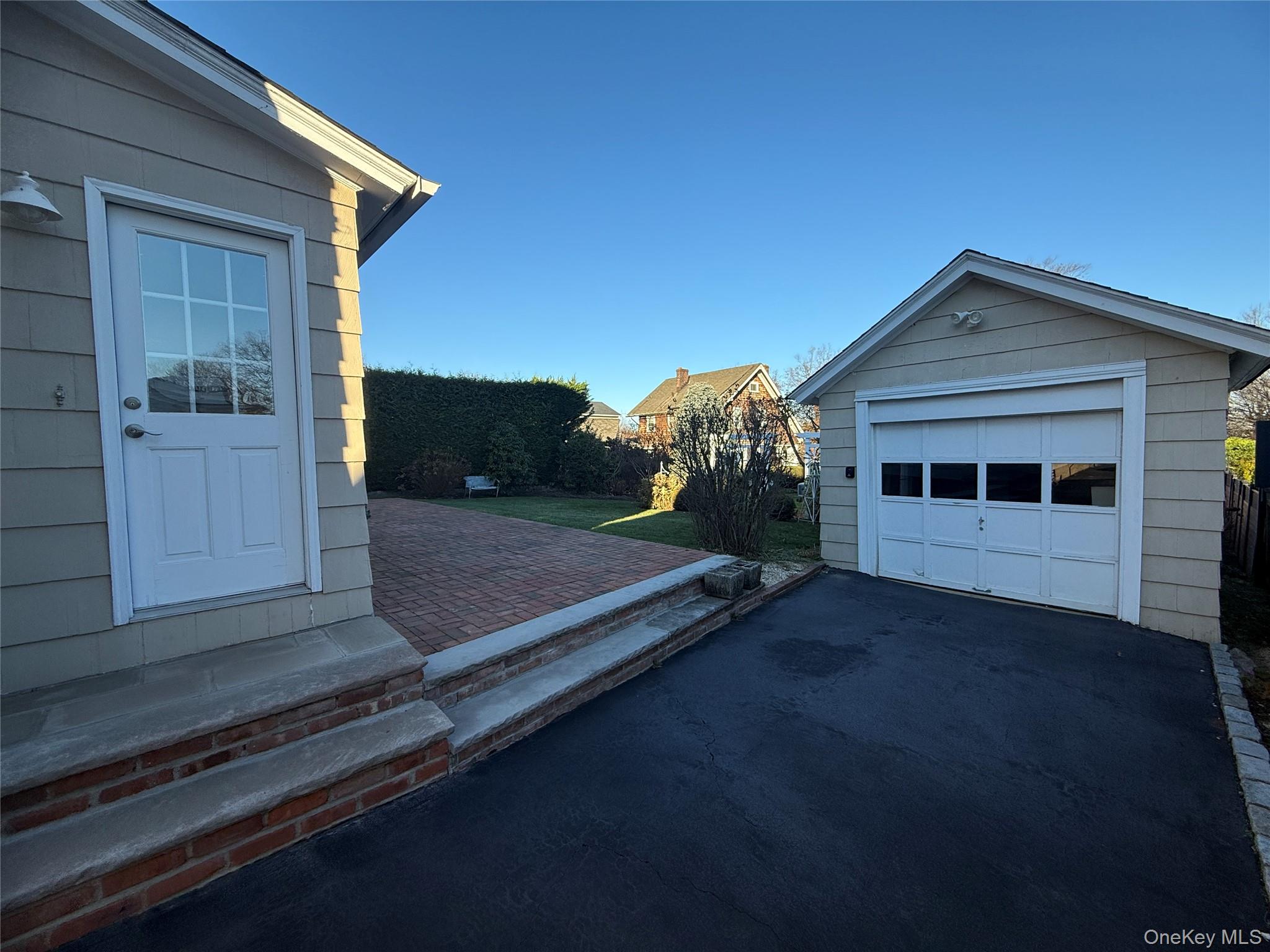 71 Hillcrest Avenue Manhasset, NY 11030 - Photo 20 of 23 a front view of a house with a yard