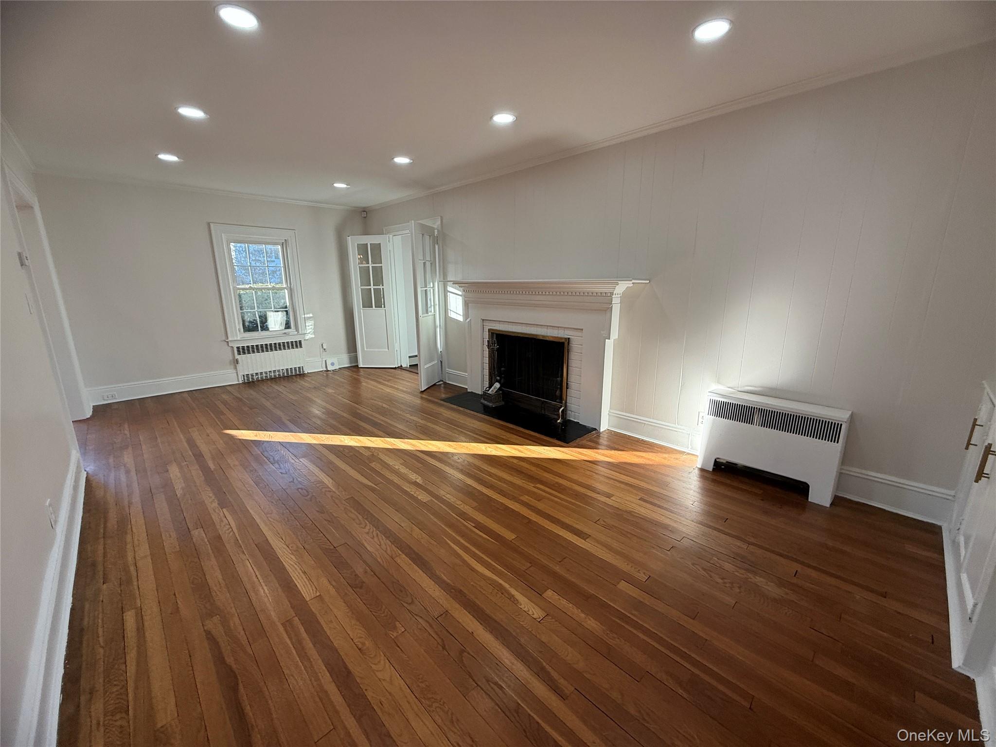 71 Hillcrest Avenue Manhasset, NY 11030 - Photo 6 of 23 a view of empty room with wooden floor and fireplace