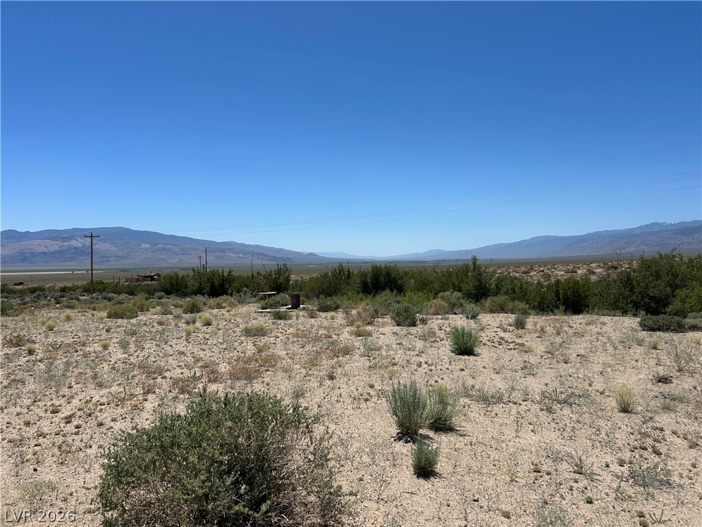 360 Mountain Creek Road Dyer, NV 89010 - Photo 5 of 23 A vast, open lot presents a panoramic vista of distant mountains under a clear sky.