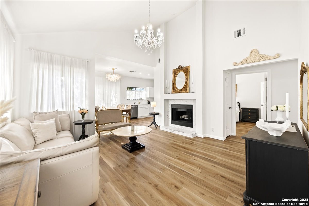 a living room with furniture a fireplace and a large mirror