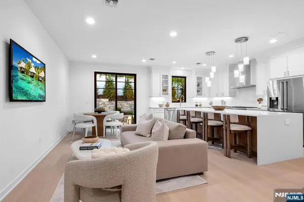 a living room with stainless steel appliances kitchen island furniture and a large window