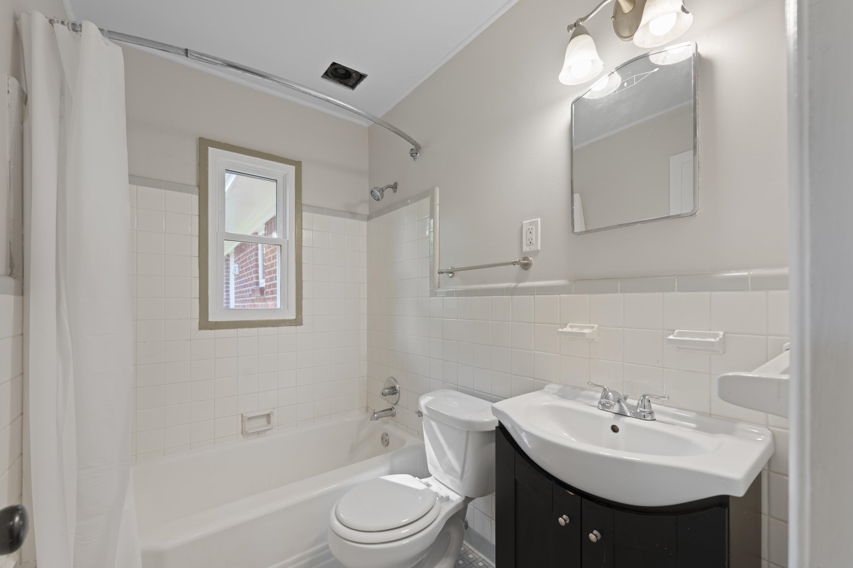 1603 Colonial Road Memphis, TN 38117 - Photo 13 of 24 a bathroom with a toilet a sink and mirror