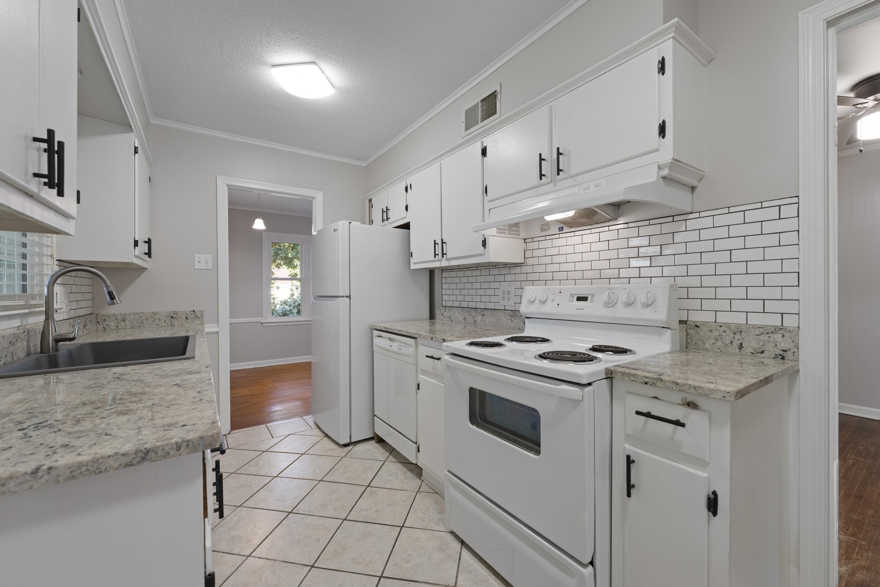 1603 Colonial Road Memphis, TN 38117 - Photo 17 of 24 a kitchen with granite countertop a sink stove and cabinets