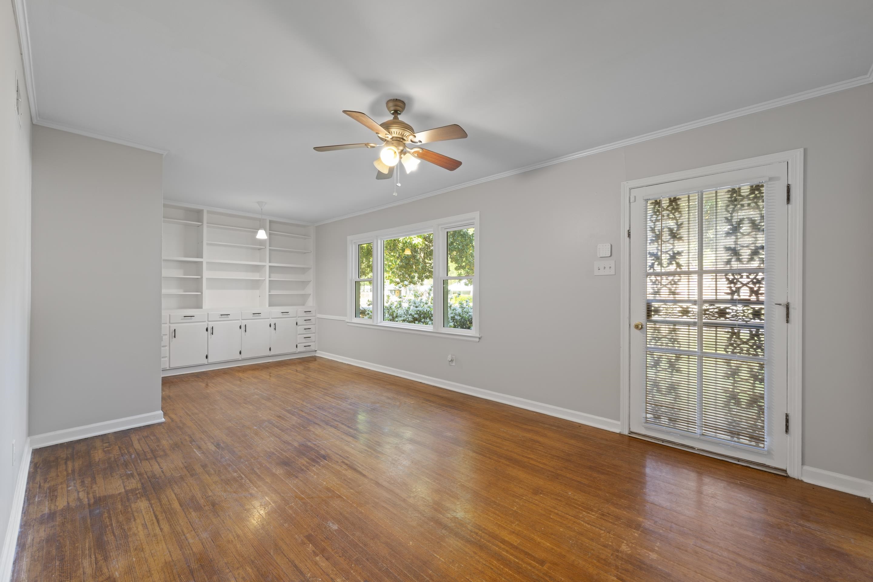 1603 Colonial Road Memphis, TN 38117 - Photo 22 of 24 an empty room with wooden floor chandelier fan and windows