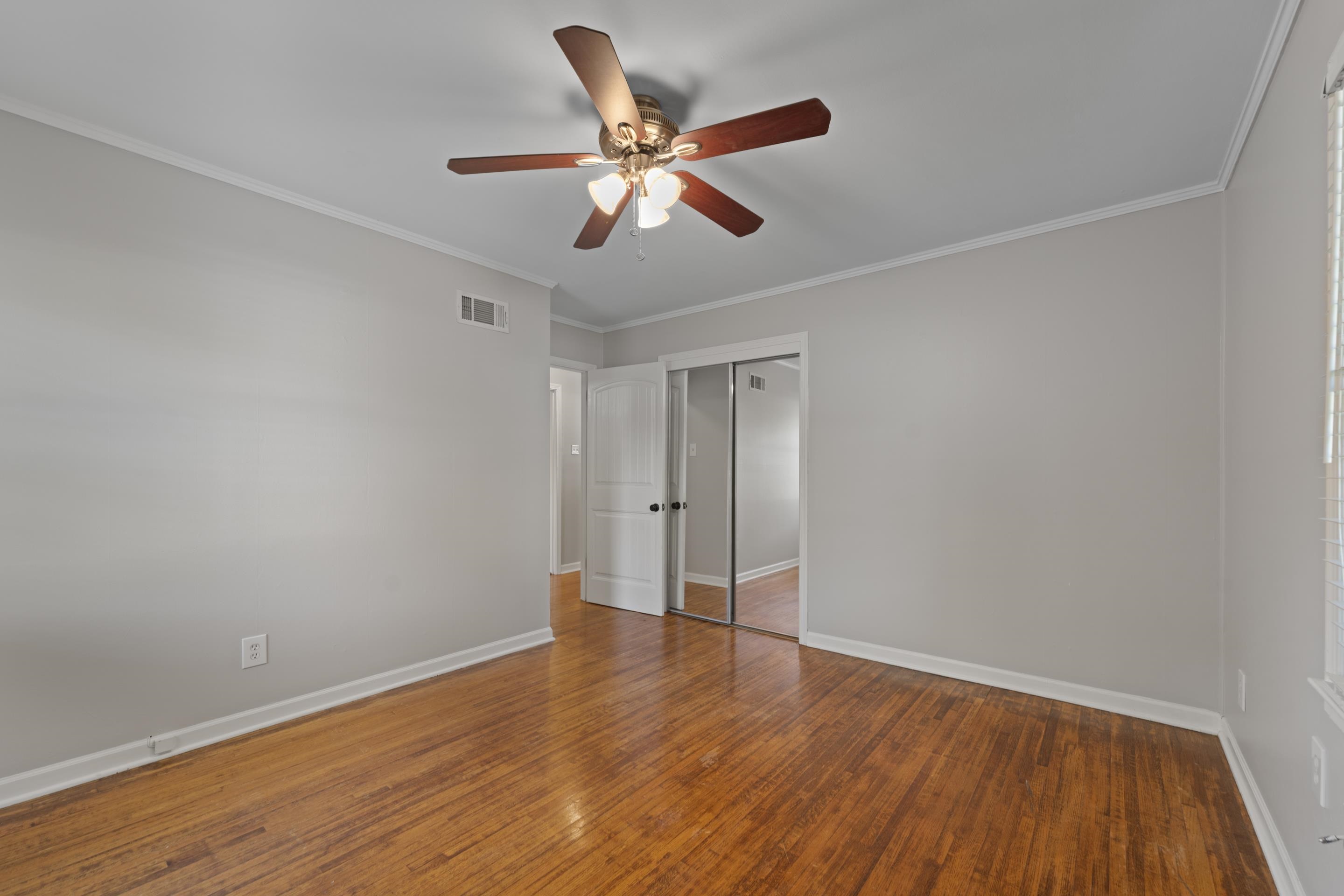 1603 Colonial Road Memphis, TN 38117 - Photo 8 of 24 a view of an empty room with wooden floor and a ceiling fan