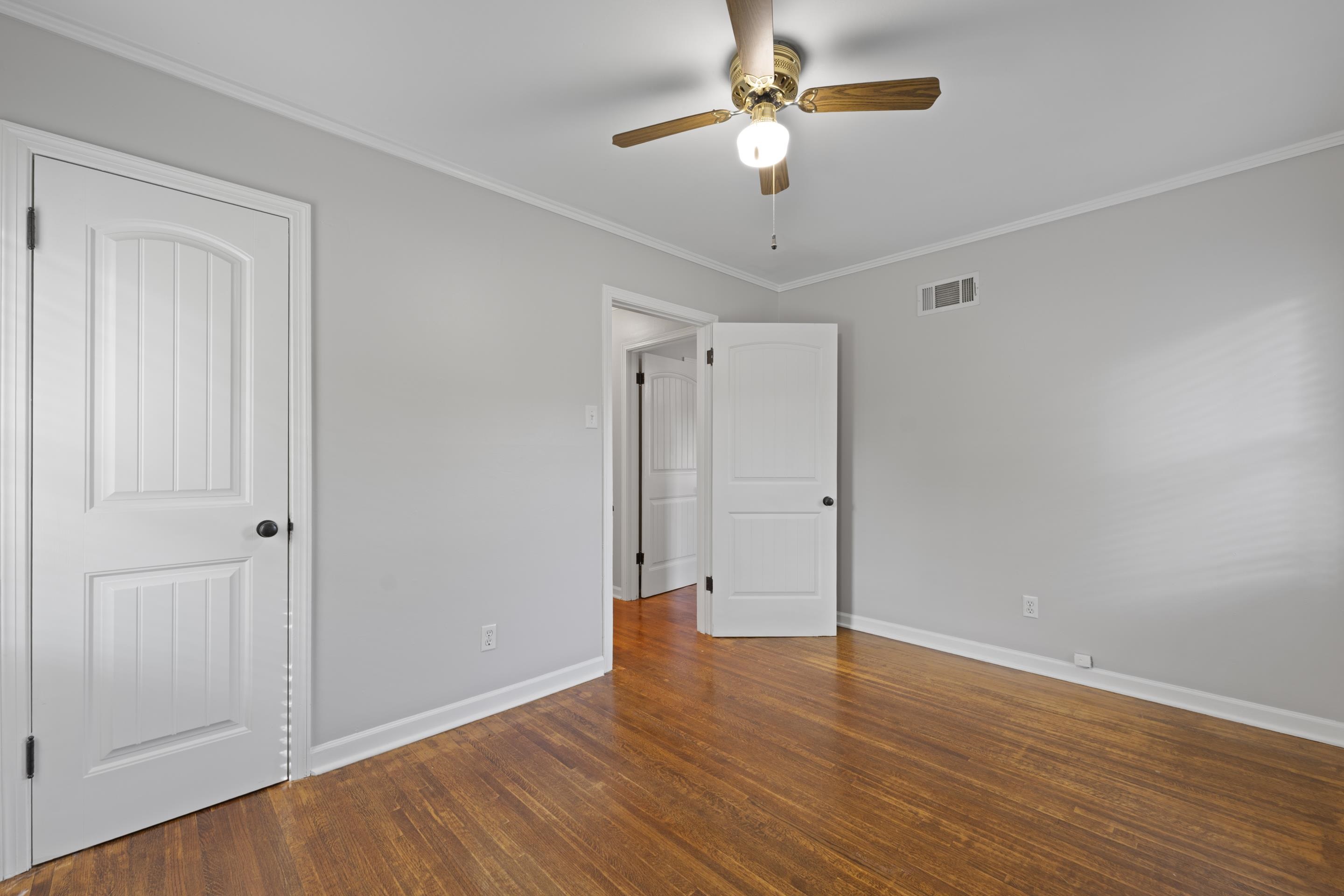 1603 Colonial Road Memphis, TN 38117 - Photo 10 of 24 an empty room with wooden floor and ceiling fan