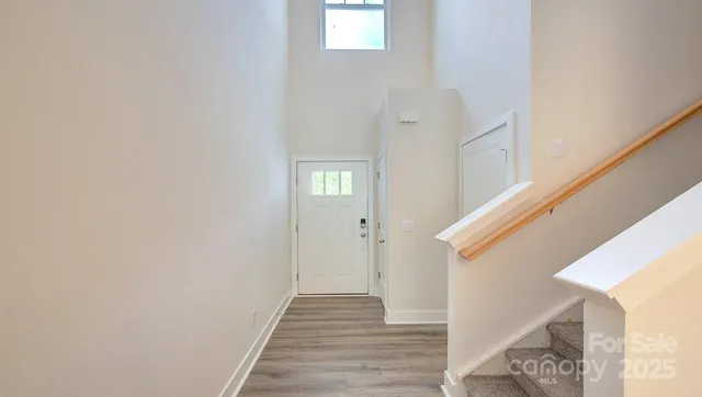 a view of a hallway with wooden floor and entryway