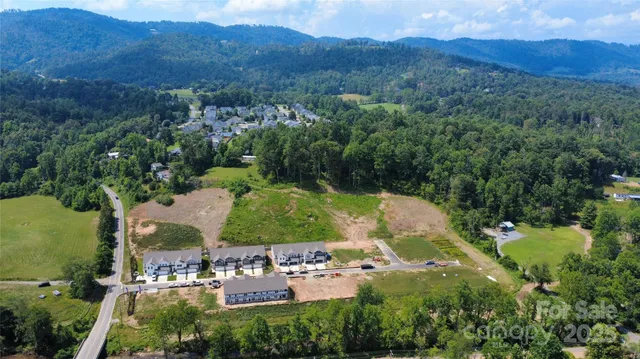an aerial view of residential house with outdoor space and trees all around