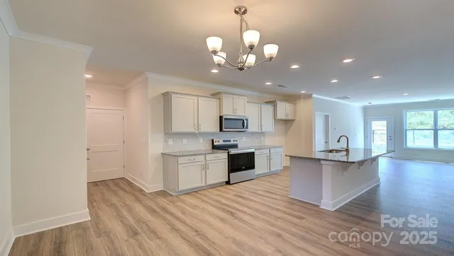 a view of a kitchen with granite countertop stainless steel appliances and wooden floor