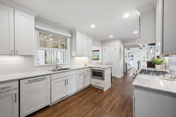 a kitchen with white cabinets stove and sink