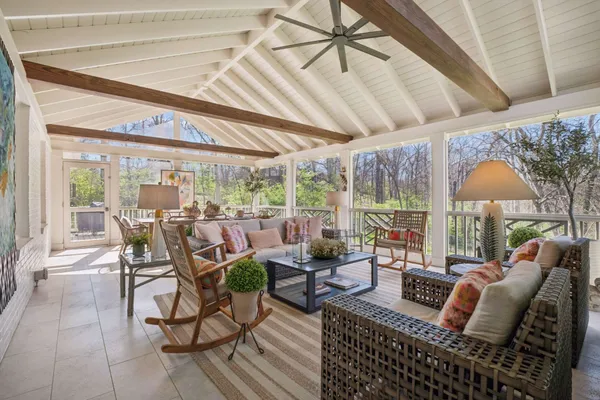 a outdoor space with lots of tables a chandelier and glass door
