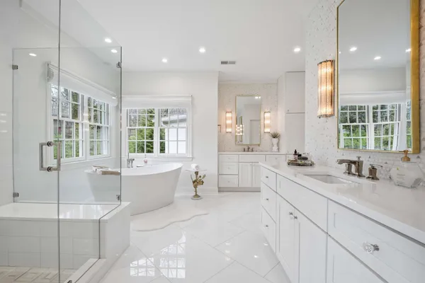 a bathroom with a tub sink shower and mirror