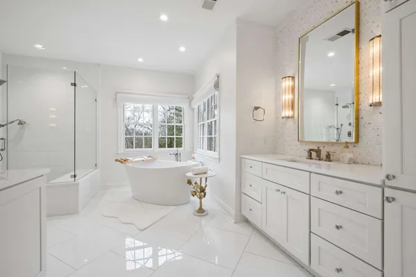 a bathroom with a tub sink toilet and mirror