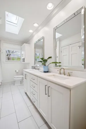 a spacious bathroom with a double vanity sink mirror and a toilet