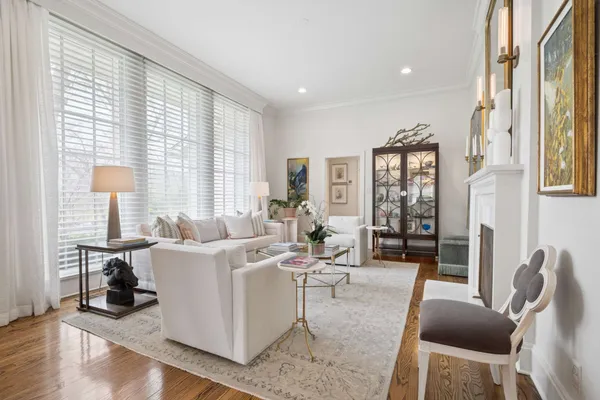 a living room with furniture floor to ceiling window and wooden floor
