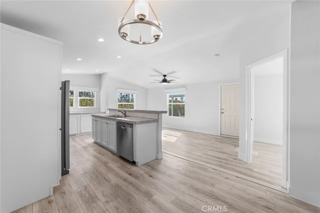 a kitchen with stainless steel appliances granite countertop a white cabinets and wooden floor