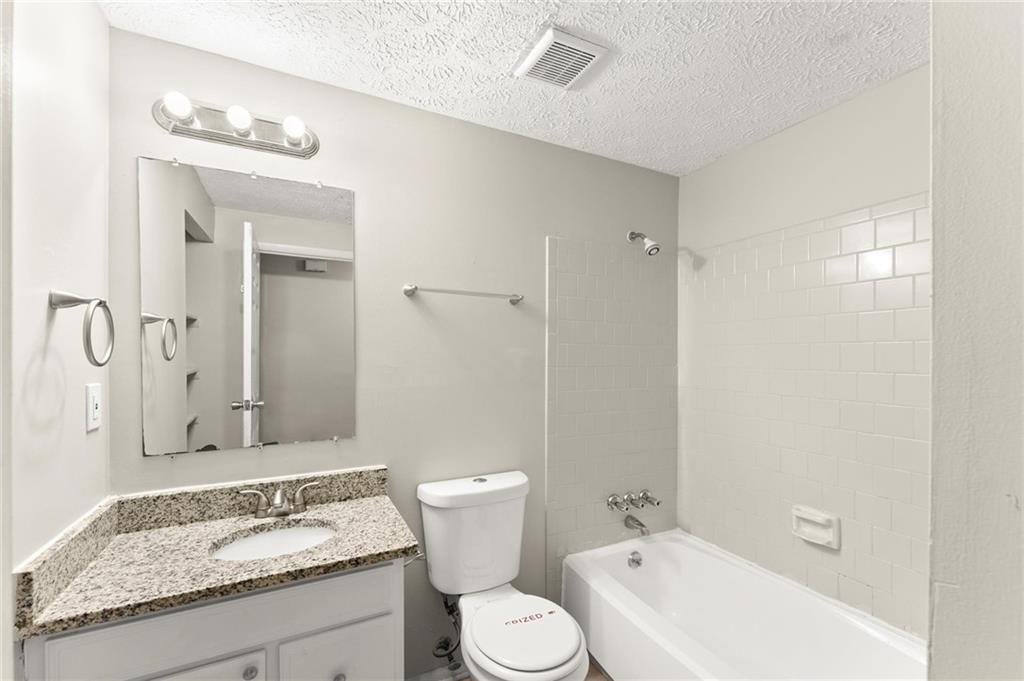 2036 Countydown Lane Stone Mountain, GA 30088 - Photo 9 of 20 a bathroom with a granite countertop sink a toilet and shower