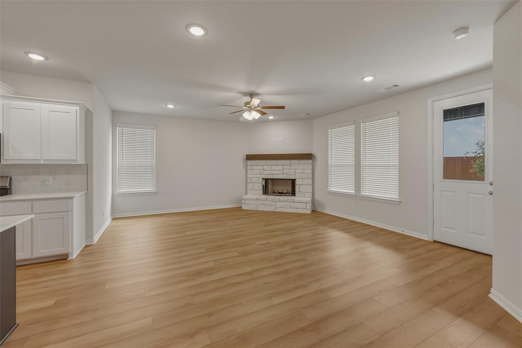 1325 Frio Drive Springtown, TX 76082 - Photo 6 of 24 Open concept living space featuring wood-finish flooring, a white stone fireplace with a wood mantle, recessed lighting, and a ceiling fan