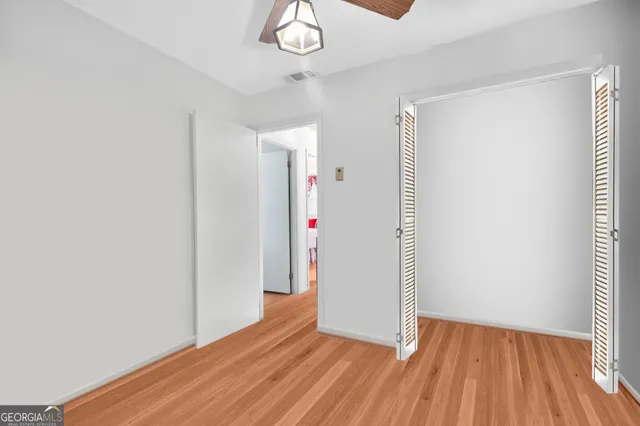 a view of a room with wooden floor and a hallway