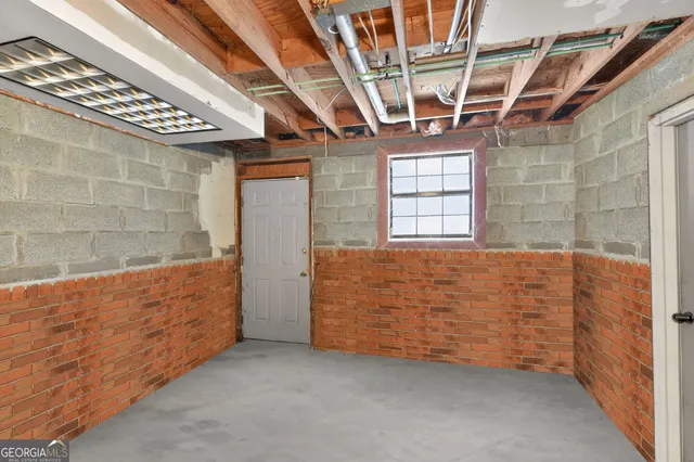 an empty room with windows and fireplace