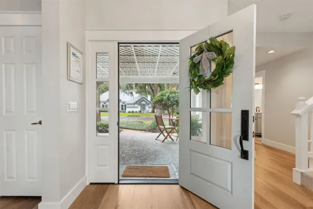 a kitchen with stainless steel appliances granite countertop a stove top oven a sink dishwasher and a refrigerator with wooden floor