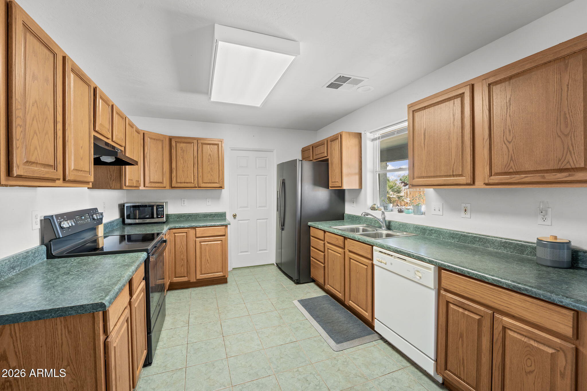 27144 Bennett Way Congress, AZ 85332 - Photo 15 of 33 a kitchen with stainless steel appliances granite countertop wooden cabinets a sink and dishwasher a stove top oven with wooden floor