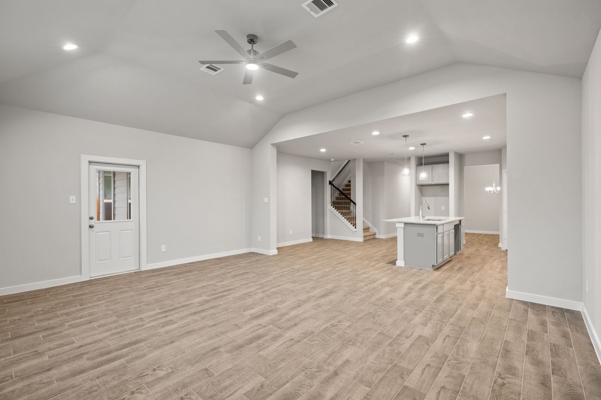 15215 Statice Trail Houston, TX 77044 - Photo 10 of 23 a view of an empty room with wooden floor and a kitchen