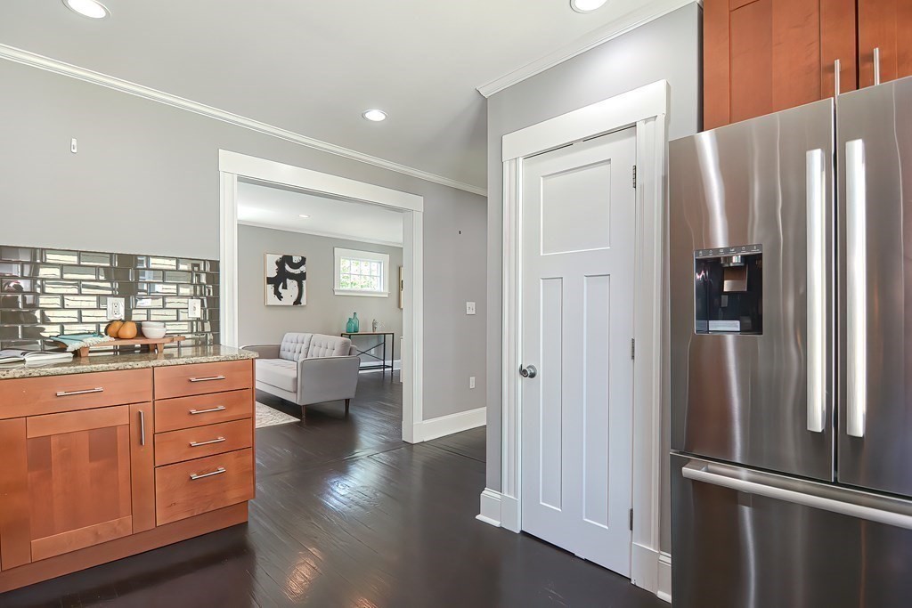 7-9 Goodway Road, Unit 2 Jamaica Plain, MA 02130 - Photo 12 of 39 a kitchen with stainless steel appliances a refrigerator and wooden floor