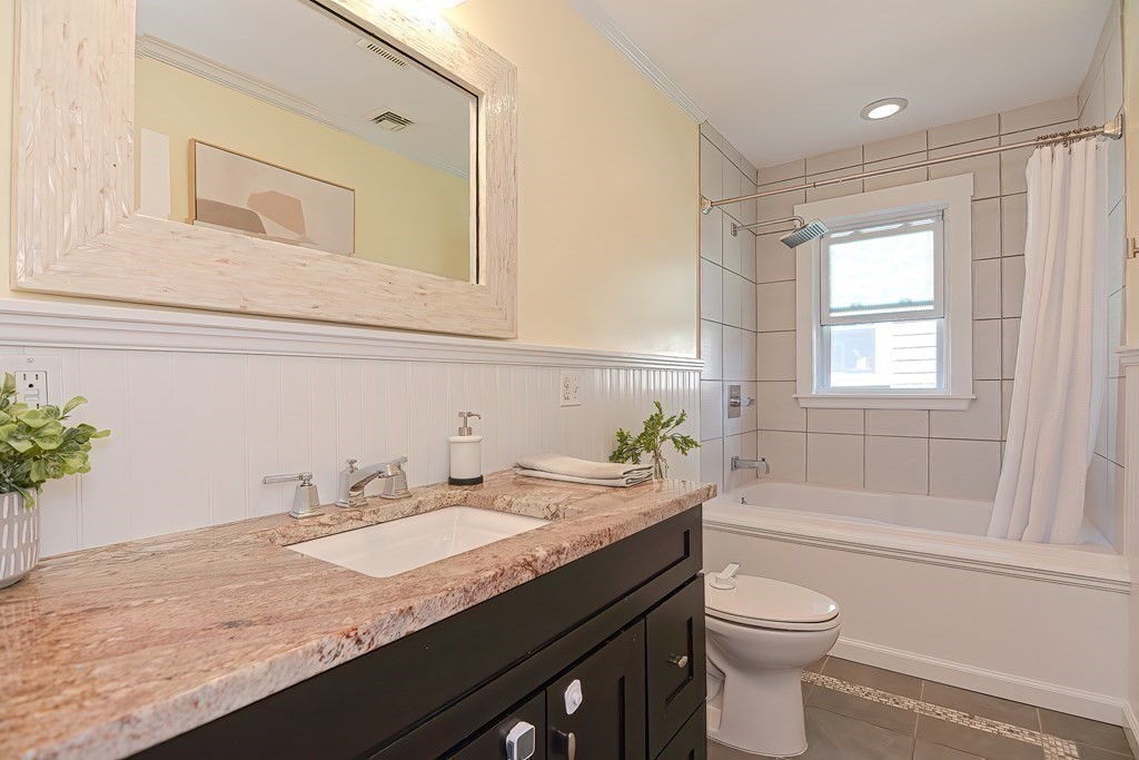 7-9 Goodway Road, Unit 2 Jamaica Plain, MA 02130 - Photo 33 of 39 a bathroom with a granite countertop sink a toilet and bathtub