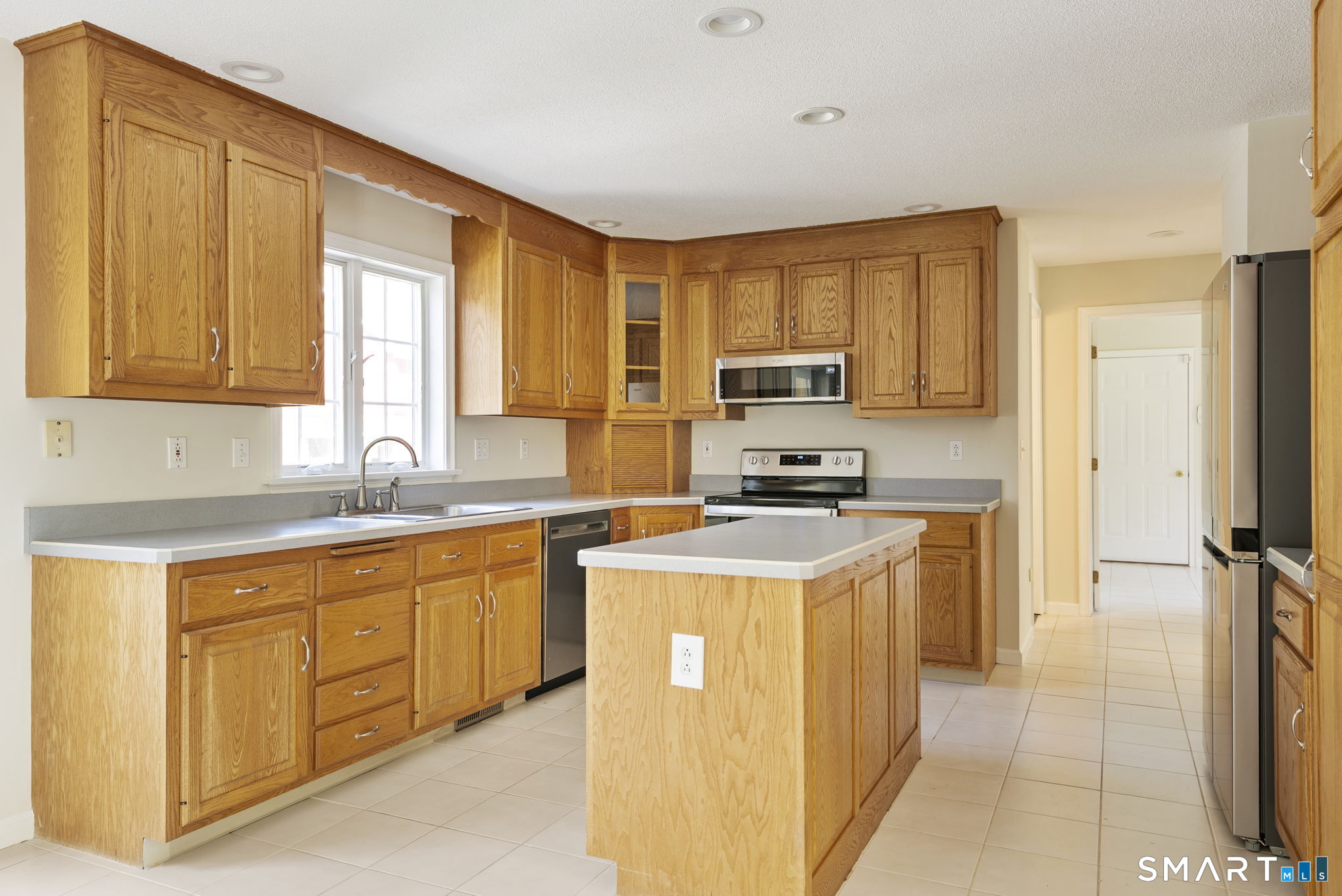 555 Waterville Road Avon, CT 06001 - Photo 23 of 40 a kitchen with stainless steel appliances granite countertop a stove a sink a refrigerator and white cabinets with wooden floor