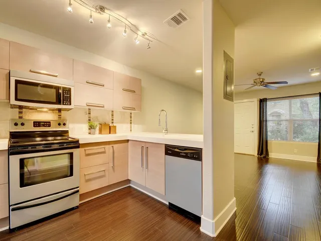 a kitchen with stainless steel appliances kitchen island granite countertop a stove a sink and a microwave