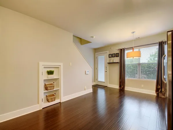 an empty room with wooden floor and windows