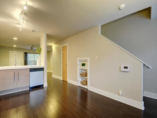 a view of an empty room with window and wooden floor