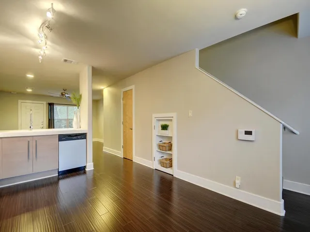 a view of an empty room with window and wooden floor