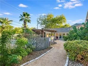 a view of a swimming pool with lounge chairs in front of house