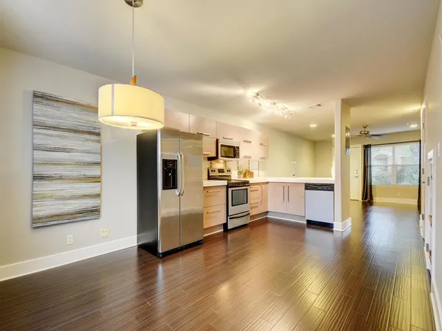 a view of a kitchen with cabinets stainless steel appliances and wooden floor