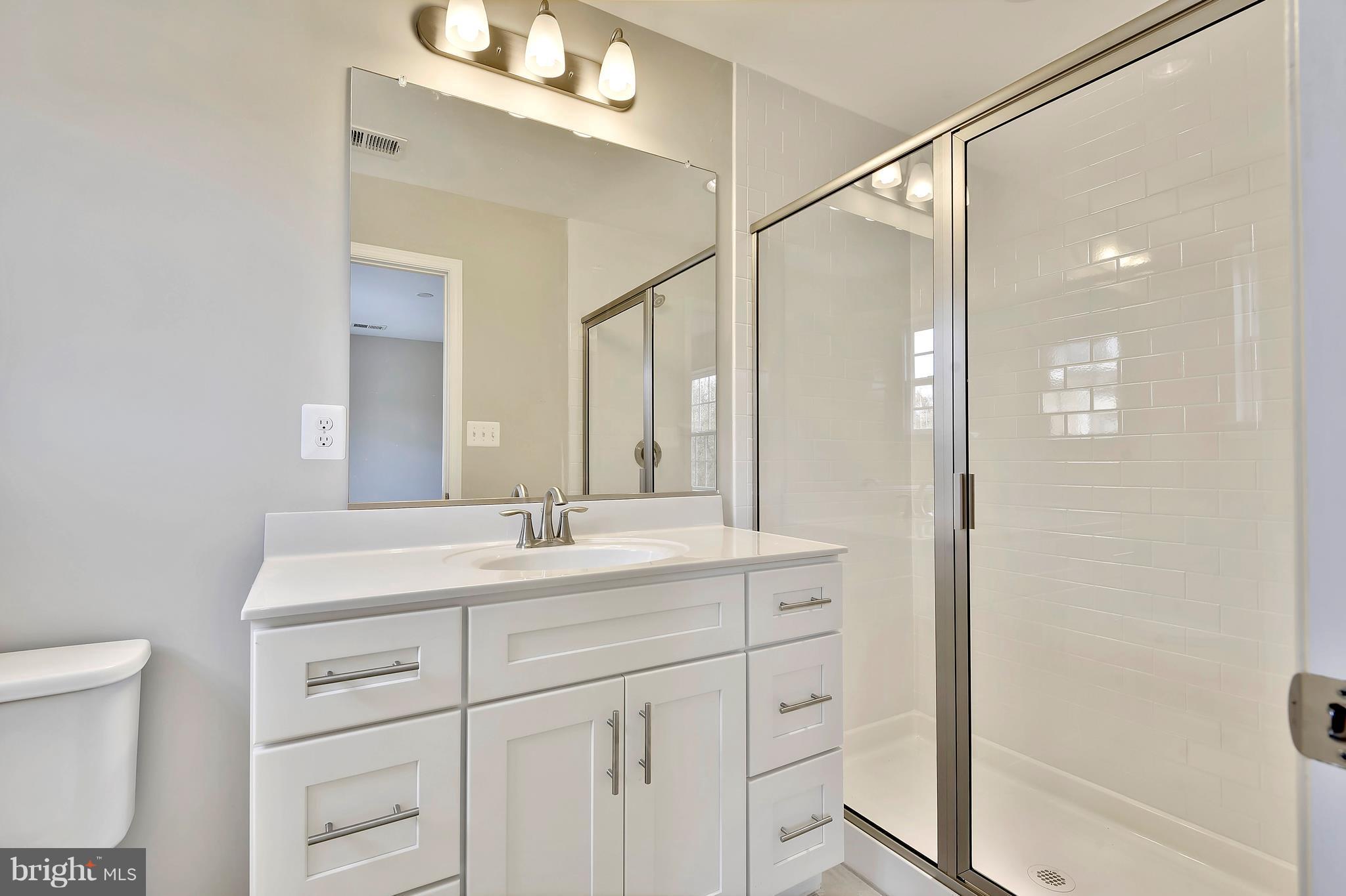 905 Cedarcroft Road Baltimore, MD 21212 - Photo 22 of 28 a bathroom with a sink a mirror and a shower