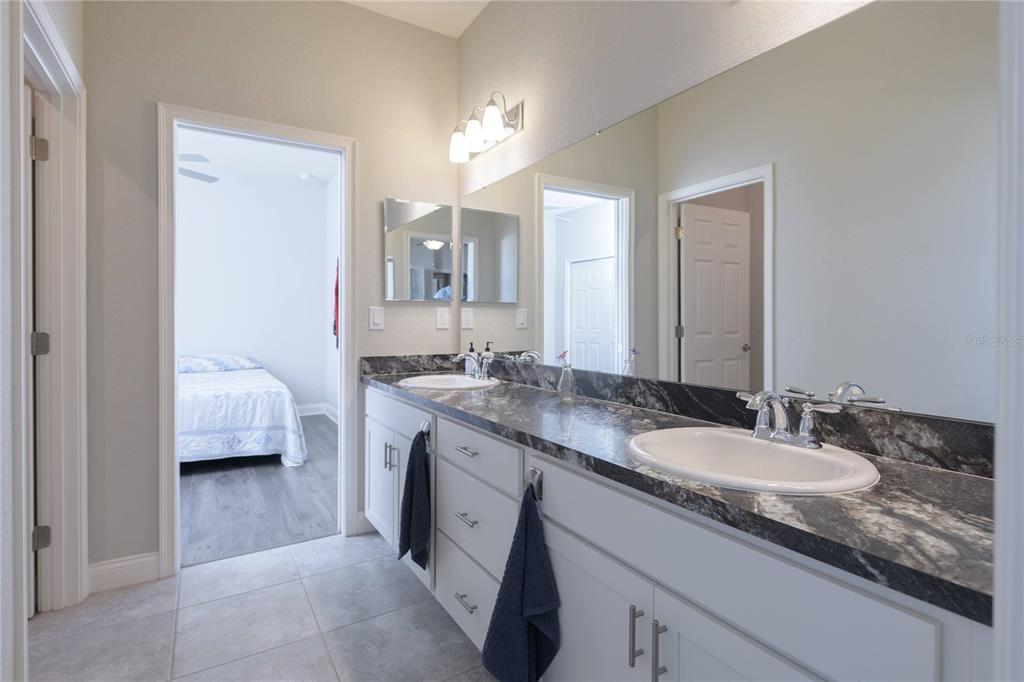 4444 Devinshire Fields Loop Plant City, FL 33567 - Photo 20 of 38 a en suite bathroom with a granite countertop double sink and a mirror